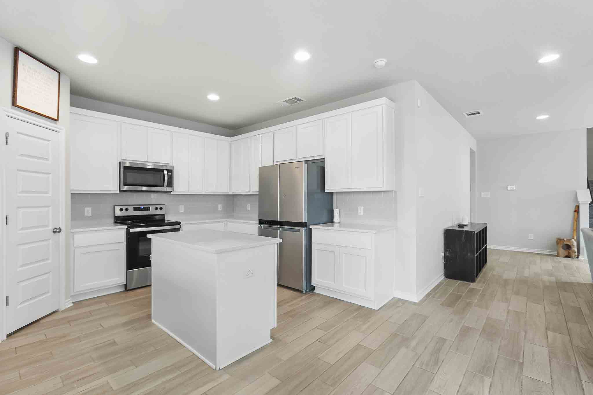 616 Barbary Coast Lane Jarrell, TX 76537 - Photo 10 of 37 a kitchen with a refrigerator and a stove top oven
