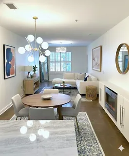 a living room with furniture a chandelier and a table