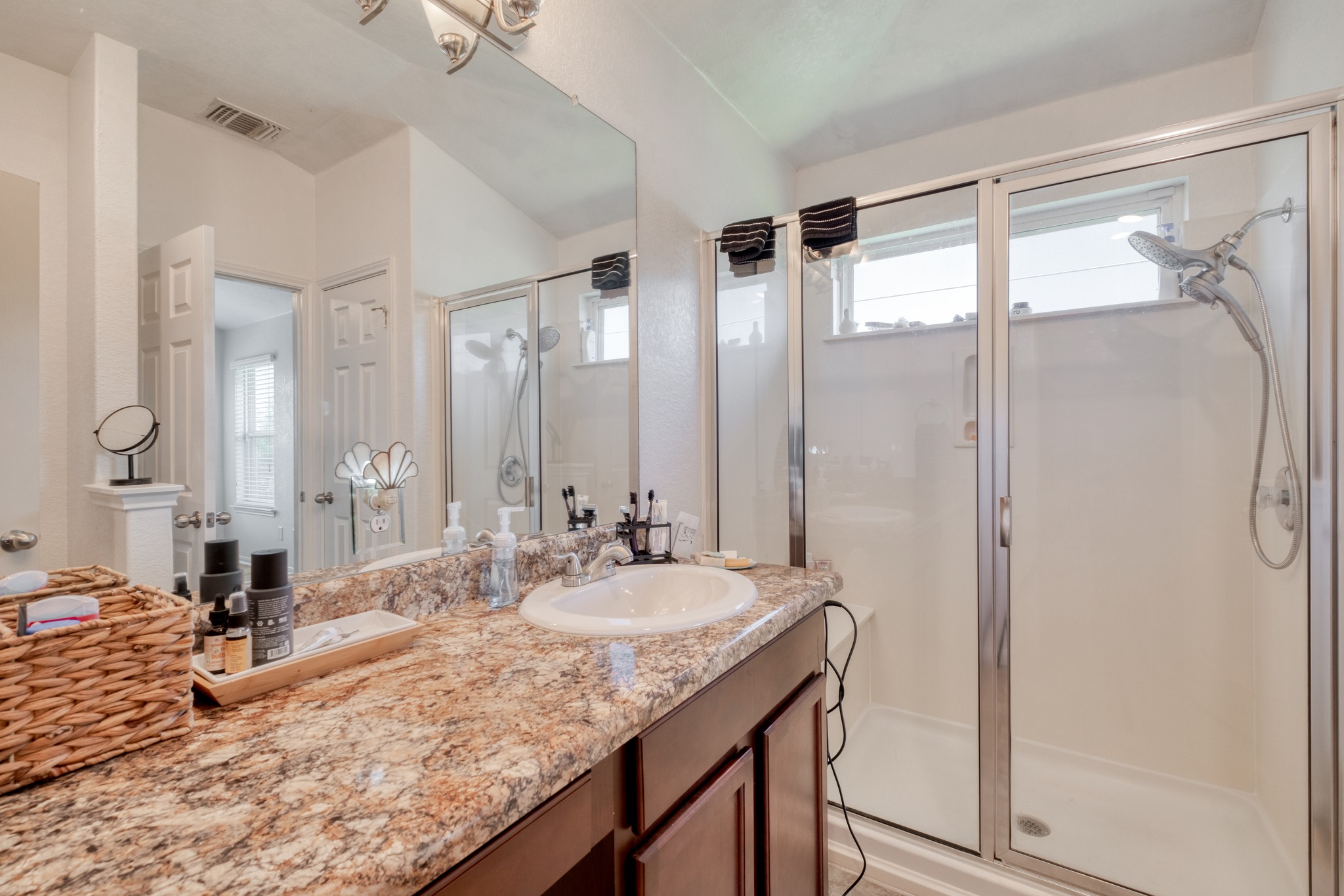 174 Falcon Drive Luling, TX 78648 - Photo 17 of 37 a bathroom with a granite countertop sink a mirror and a shower