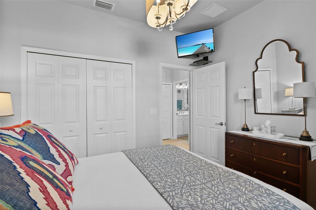 20219 Tesoro Drive Venice, FL 34293 - Photo 42 of 98 a bedroom with a bed and a mirror