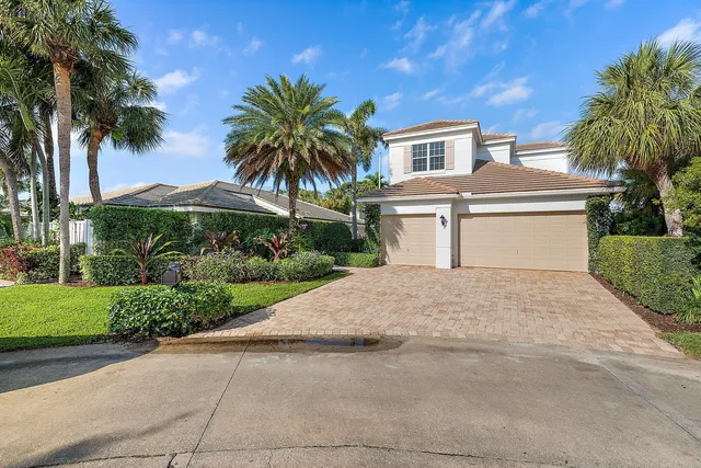 a front view of a house with a yard and palm tree