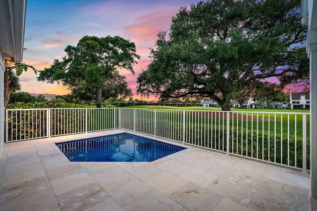 an aerial view of a house with a yard and lake view in back