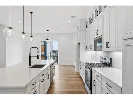 a large kitchen with granite countertop a sink a stove and cabinets