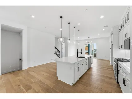 a large white kitchen with a stove top oven