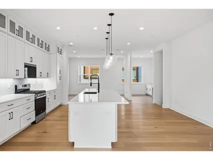 a large white kitchen with cabinets a sink and a stove
