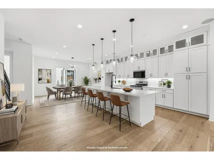 a kitchen with white cabinets and chairs