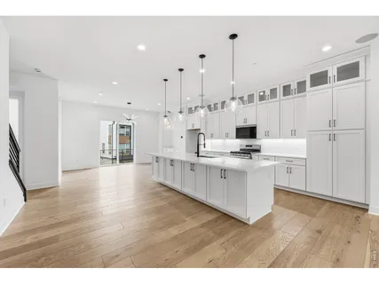 a open kitchen with white cabinets and stainless steel appliances