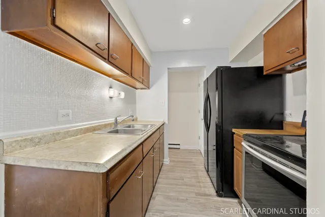 a kitchen with stainless steel appliances granite countertop a sink and a refrigerator