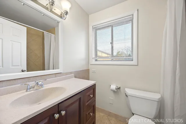 a bathroom with a granite countertop sink a toilet and a mirror