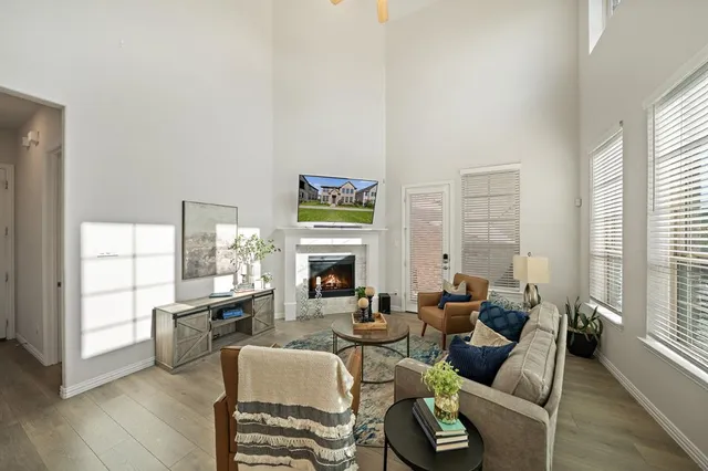 a living room with fireplace furniture and a large window