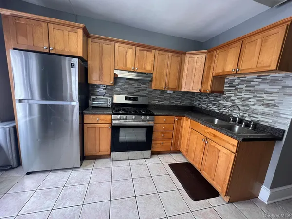 a kitchen with stainless steel appliances granite countertop a stove a refrigerator and a sink