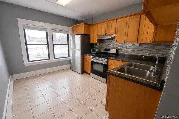 a kitchen with stainless steel appliances granite countertop a stove a sink and a refrigerator
