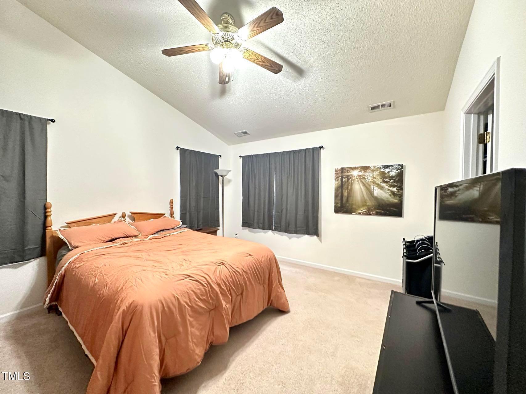 114 Graystar Road Apex, NC 27502 - Photo 11 of 14 a bedroom with a bed and a flat screen tv