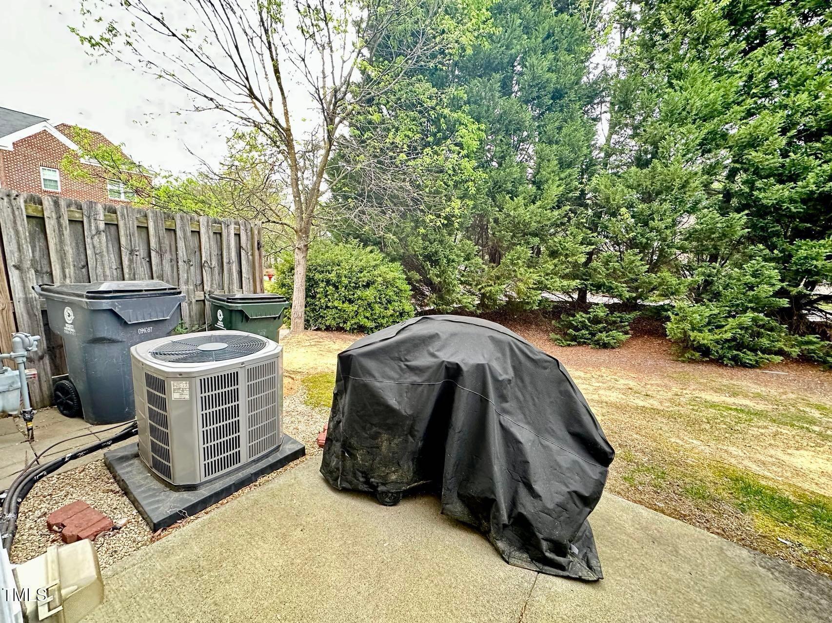 114 Graystar Road Apex, NC 27502 - Photo 13 of 14 a view of a patio with table and chairs with wooden fence and plants