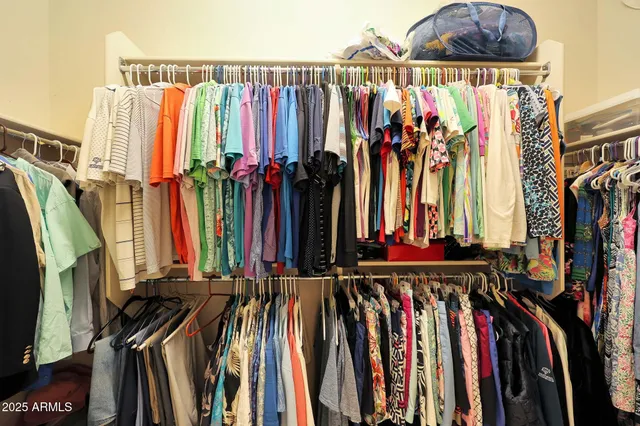 a view of walk in closet with clothes