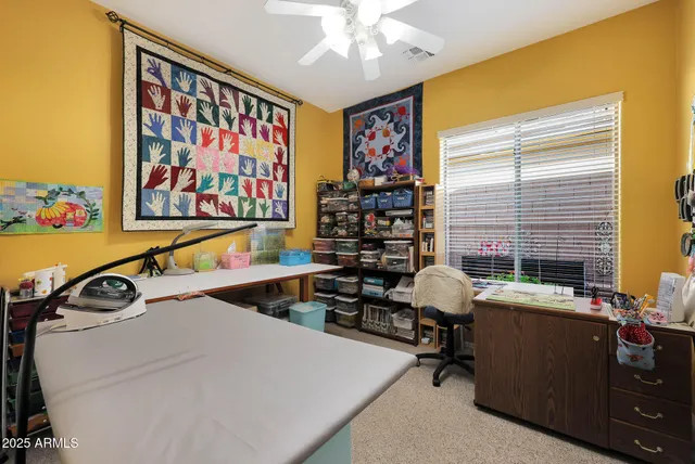 a bedroom with a baby bed a desk and a baby crib