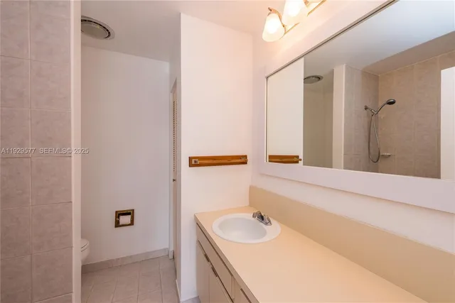 a bathroom with a granite countertop toilet and a shower