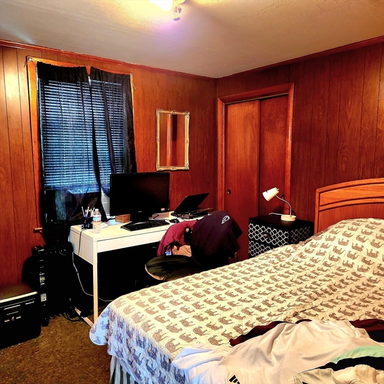 6 McIntyre Street Lowell, MA 01851 - Photo 6 of 12 a bedroom with a bed and a dresser