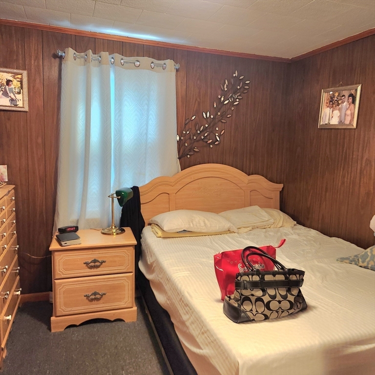 6 McIntyre Street Lowell, MA 01851 - Photo 7 of 12 a bedroom with a bed and a chandelier