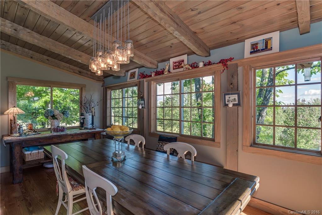 1180 Golf Course Road Tryon, NC 28782 - Photo 9 of 24 a view of a dining room with furniture a chandelier and wooden floor