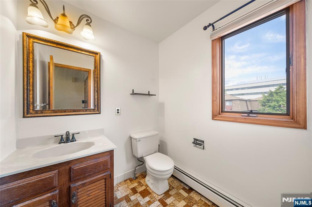 140 Allwood Road, Unit C Clifton, NJ 07012 - Photo 17 of 31 a bathroom with a toilet a sink and a mirror