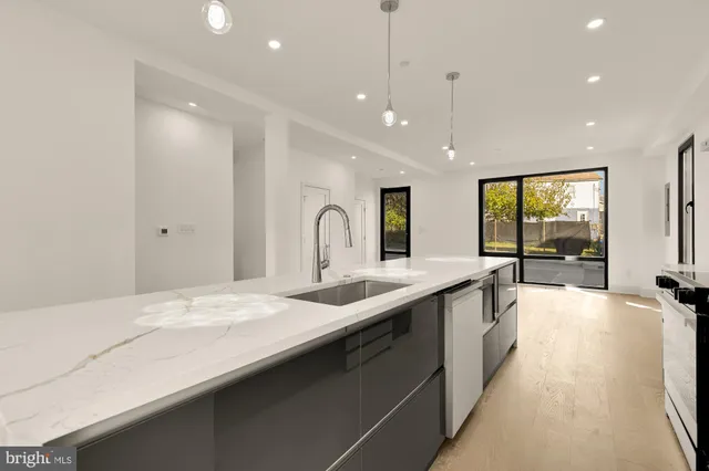 a large kitchen with kitchen island a large window and a sink