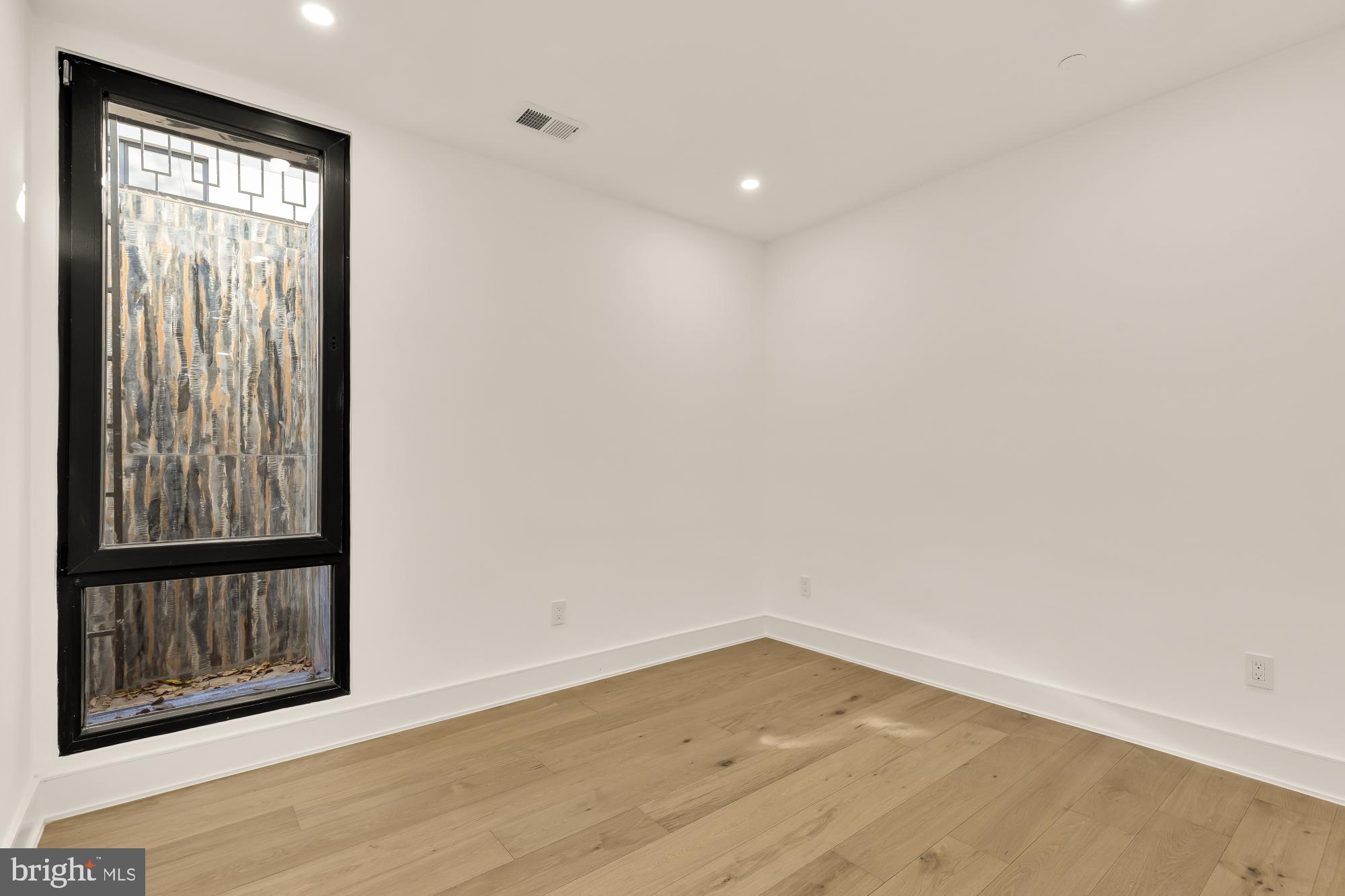 1810 Central Place Northeast, Unit 1 Washington, DC 20002 - Photo 27 of 33 a view of an empty room with wooden floor and a window