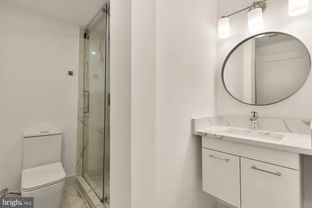 a bathroom with a toilet a sink and mirror
