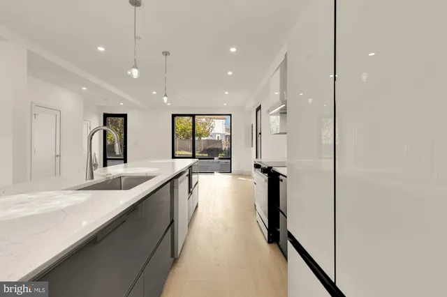 a large kitchen with kitchen island a large counter top space a sink and stainless steel appliances