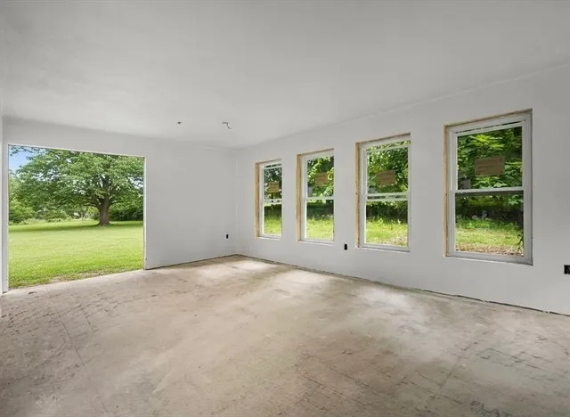 a view of an empty room with a window and a yard