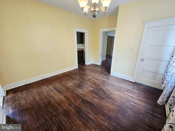 a view of a room with wooden floor and chandelier