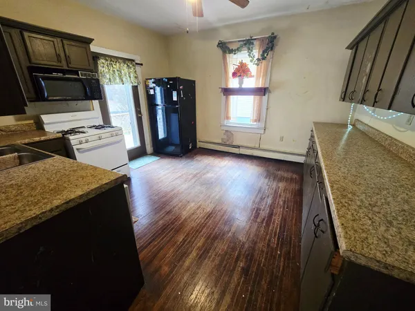 a view of a kitchen with fridge and wooden floor