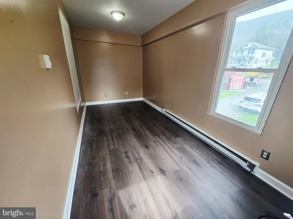 wooden floor in an empty room with a window