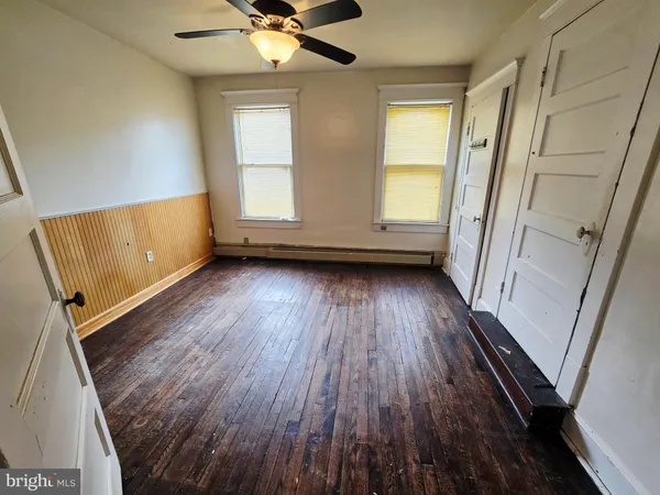 a view of empty room with wooden floor