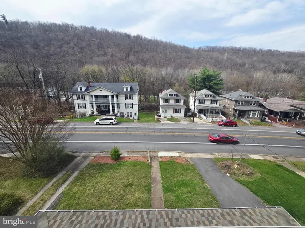 a front view of residential houses with yard and mountain view in back