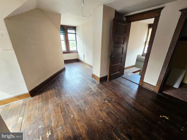 view of an empty room with wooden floor and a window
