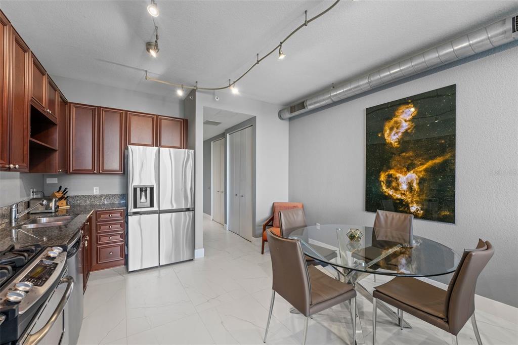 150 East Robinson Street, Unit 1007 Orlando, FL 32801 - Photo 11 of 31 a kitchen with stainless steel appliances kitchen island hardwood floor and a refrigerator