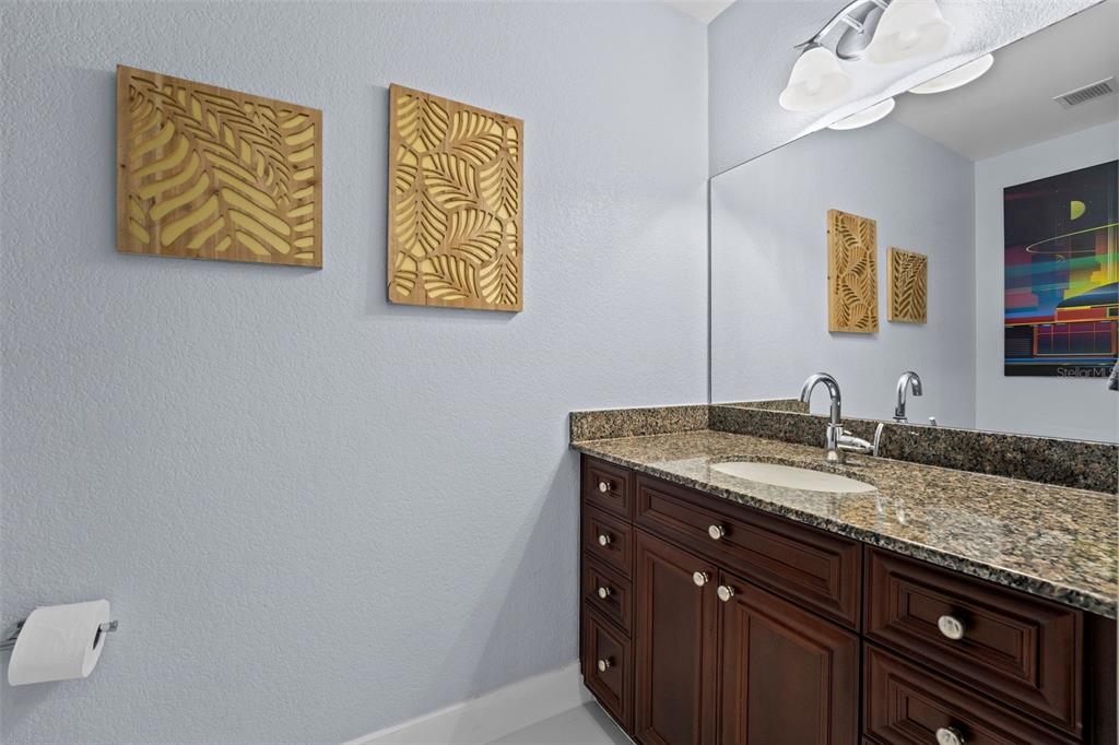 150 East Robinson Street, Unit 1007 Orlando, FL 32801 - Photo 26 of 31 a bathroom with a granite countertop sink a mirror and vanity