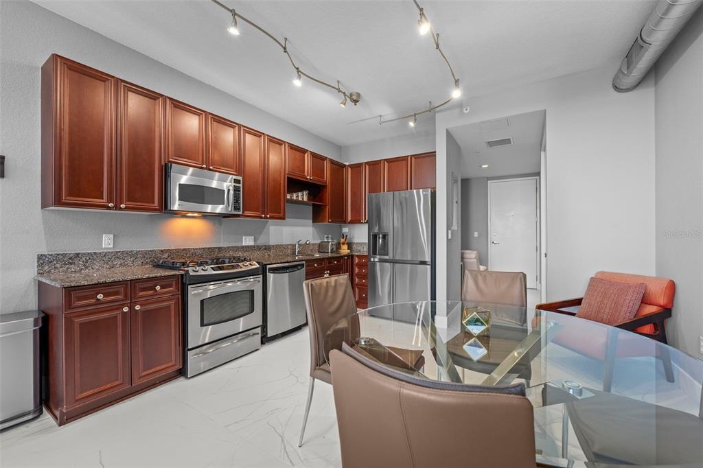 150 East Robinson Street, Unit 1007 Orlando, FL 32801 - Photo 9 of 31 a kitchen with stainless steel appliances granite countertop a stove top oven a sink and a refrigerator