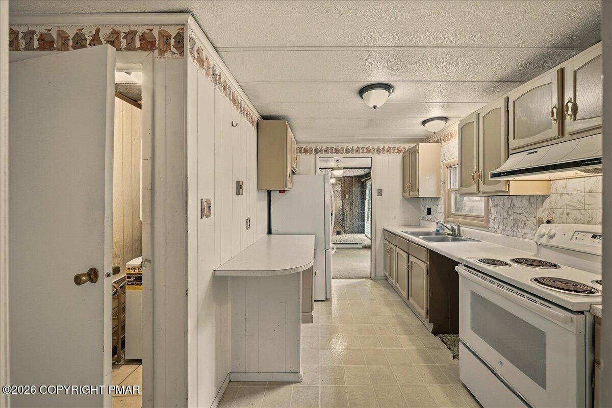 3416 Walnut Road Gilbert, PA 18331 - Photo 15 of 27 a kitchen with stainless steel appliances a refrigerator a sink and white cabinets