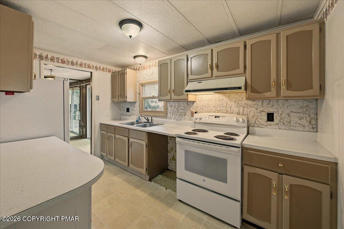 3416 Walnut Road Gilbert, PA 18331 - Photo 16 of 27 a kitchen with a stove sink and cabinets