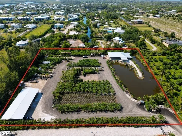 an aerial view of residential houses with outdoor space and trees