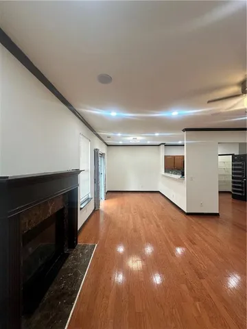 a view of empty room with wooden floor and fireplace