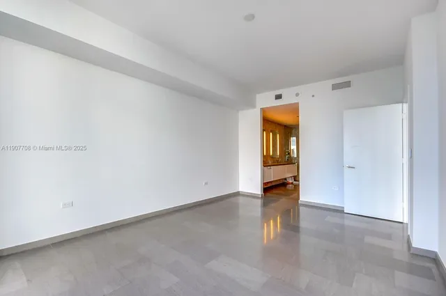 an empty room with closet and wooden floor