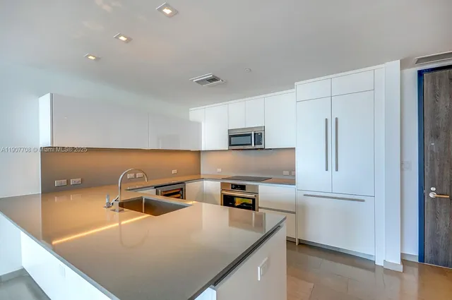 a bathroom with a granite countertop sink a toilet and a mirror