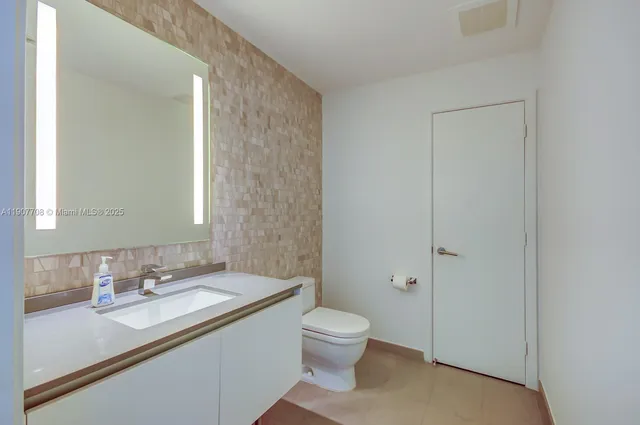 a bathroom with a granite countertop toilet a sink and a shower