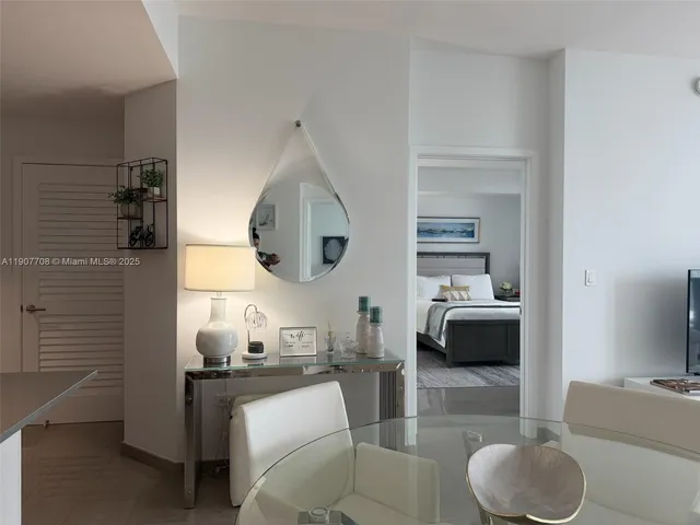 a bedroom with a bed a couch and a flat tv screen next to a window