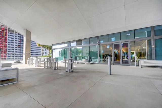 a swimming pool with outdoor seating and a large window