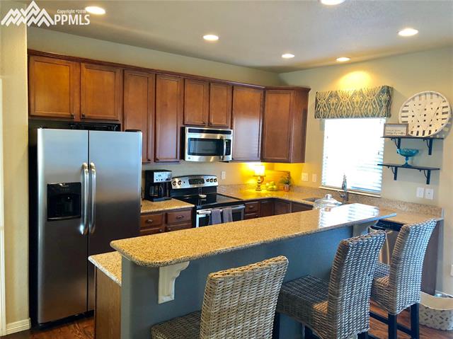 7888 Calabash Road Colorado Springs, CO 80908 - Photo 5 of 25 Kitchen with Granite Countertops, and Bar Seating