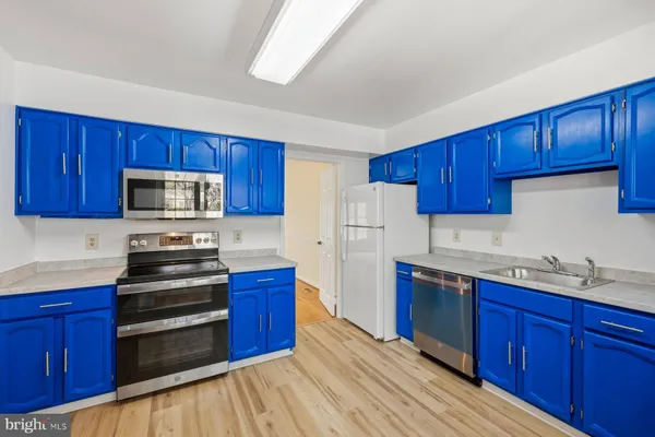 a kitchen with stainless steel appliances a stove a refrigerator and wooden cabinets